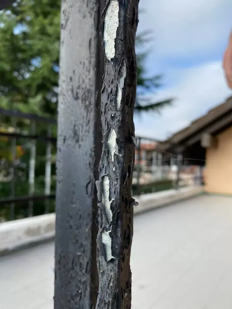 Sablage d&rsquo;une rambarde de balcon en acier avec une ancienne peinture qui s&rsquo;écaille
