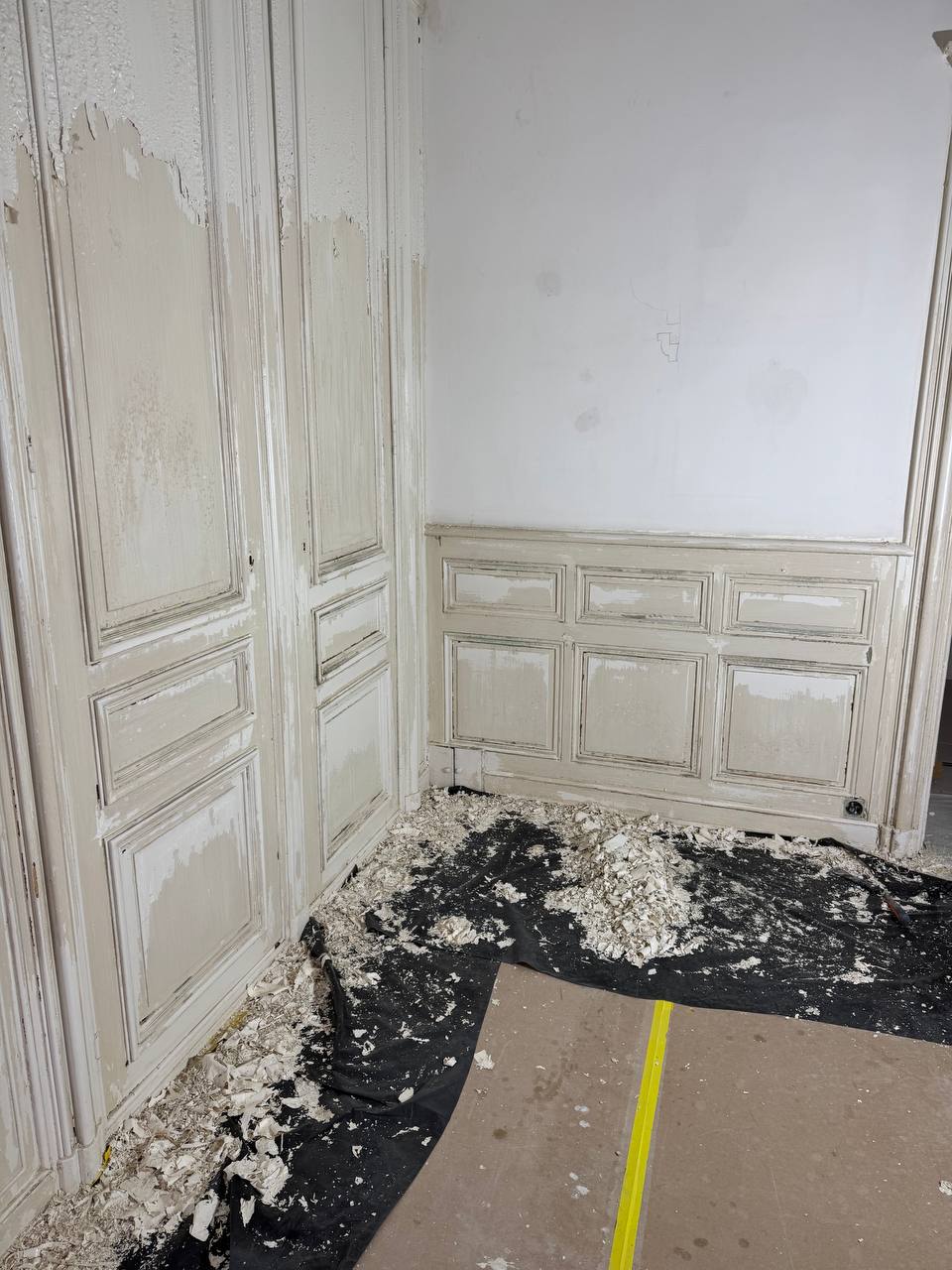Salle avec boiseries et portes anciennes – chantier de décapage au plomb
