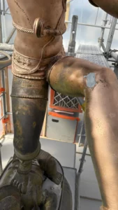Restauration de statue en bronze : jambe de Shiva avant et après traitement, contraste entre bronze oxydé et bronze restauré